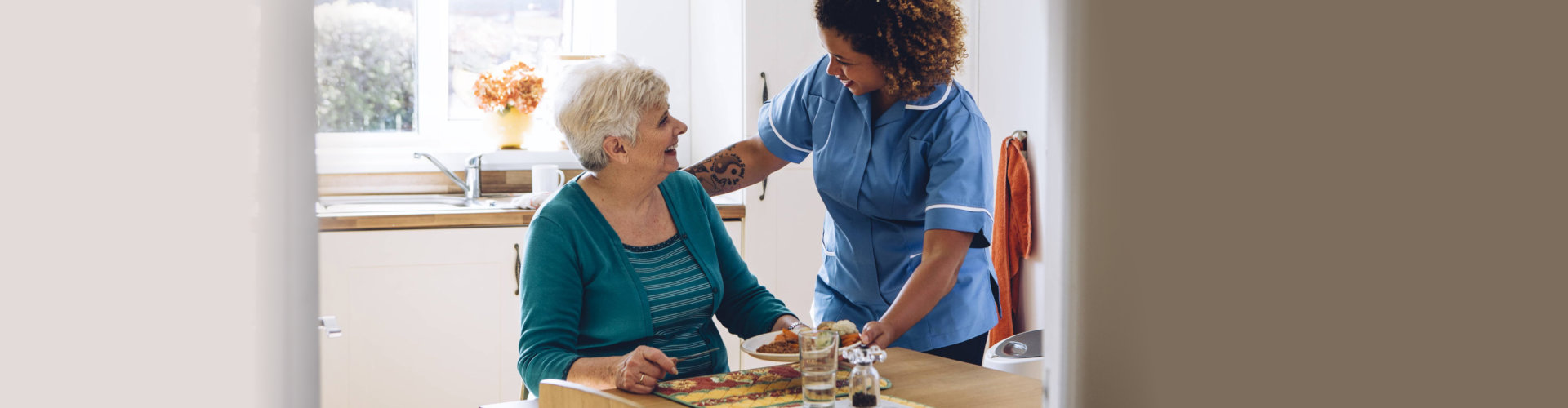 caregiver serving meal to her senior patient